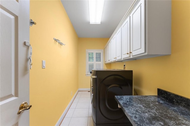 clothes washing area featuring baseboards, light tile patterned floors, washer / clothes dryer, and cabinet space