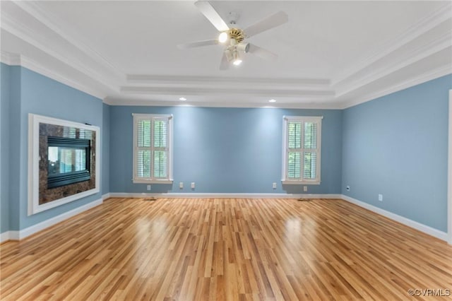 empty room featuring ornamental molding, a healthy amount of sunlight, and a tray ceiling