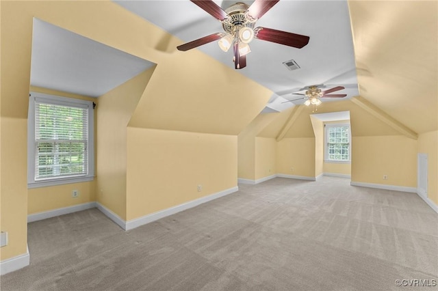 additional living space with carpet, visible vents, a healthy amount of sunlight, and a ceiling fan