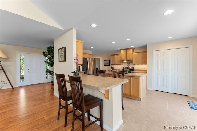 637 Mallard Bay Dr, Heathsville, VA 22473 - kitchen with a breakfast bar, a peninsula, light countertops, under cabinet range hood, and appliances with stainless steel finishes