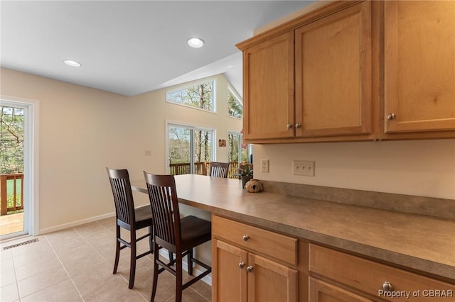637 Mallard Bay Dr, Heathsville, VA 22473 - kitchen featuring light tile patterned floors, brown cabinetry, visible vents, recessed lighting, and lofted ceiling