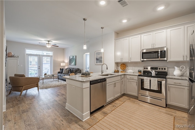 10526 Stony Bluff Dr Unit 308, Ashland, VA 23005 - kitchen featuring tasteful backsplash, a peninsula, light stone countertops, stainless steel appliances, and a sink