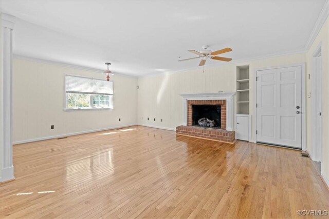 unfurnished living room with ornamental molding, built in features, and light wood finished floors