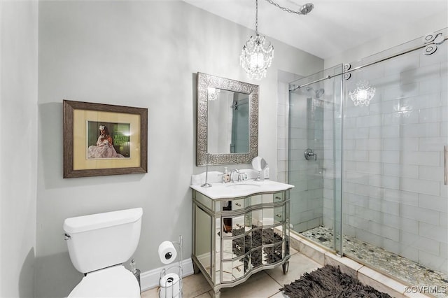 bathroom with a stall shower, tile patterned floors, toilet, a chandelier, and vanity