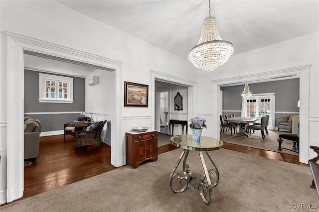 dining space with a chandelier, wood finished floors, and a wall unit AC
