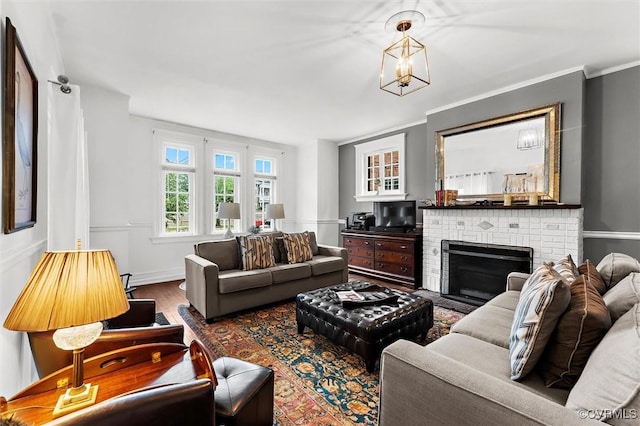 living room featuring a brick fireplace and wood finished floors