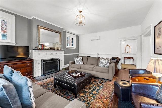 living area with wood finished floors, a wall mounted air conditioner, and a brick fireplace