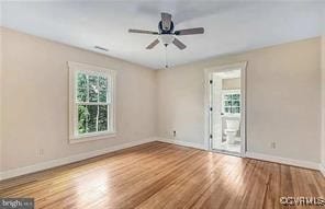 unfurnished room with baseboards, ceiling fan, and wood finished floors