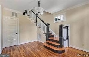 interior space featuring crown molding, stairs, and wood finished floors