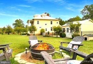 exterior space featuring an outdoor fire pit and fence