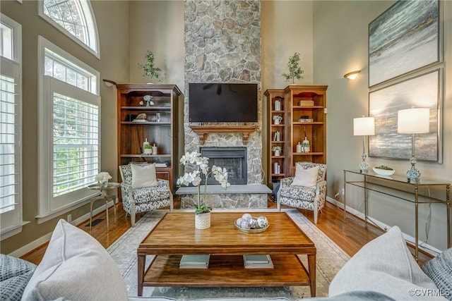 2600 Mulberry Row Rd, Midlothian, VA 23113 - living room featuring a stone fireplace, a high ceiling, wood finished floors, and baseboards