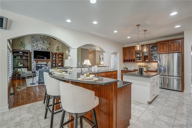2600 Mulberry Row Rd, Midlothian, VA 23113 - kitchen featuring stainless steel fridge with ice dispenser, a center island, glass insert cabinets, a sink, and a kitchen breakfast bar