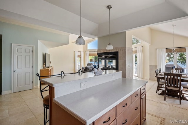 kitchen featuring a kitchen island, hanging light fixtures, light countertops, open floor plan, and light tile patterned flooring