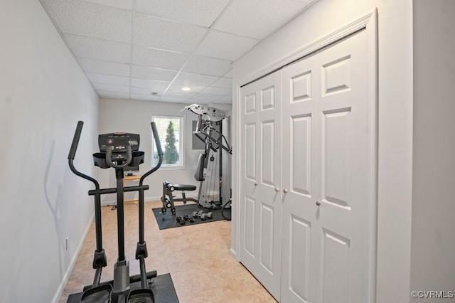 workout area with baseboards and a paneled ceiling