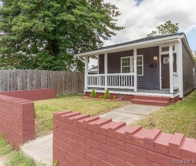 bungalow-style house with a porch, fence, and a front lawn