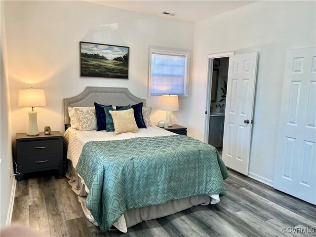 bedroom featuring wood finished floors, baseboards, and visible vents