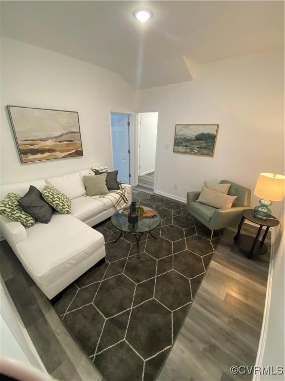 living room with baseboards, vaulted ceiling, and wood finished floors