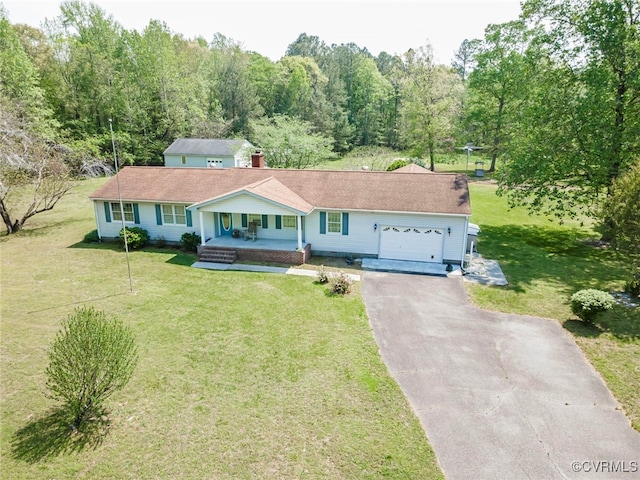 ranch-style house featuring an attached garage, a porch, a front lawn, and aphalt driveway