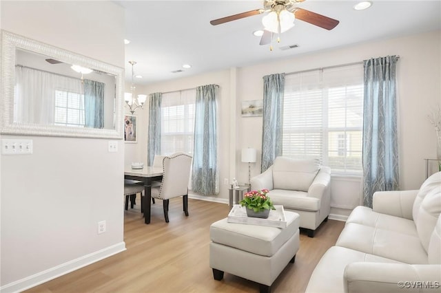 17318 Library Blvd, Ruther Glen, VA 22546 - living room with visible vents, baseboards, light wood finished floors, and ceiling fan with notable chandelier