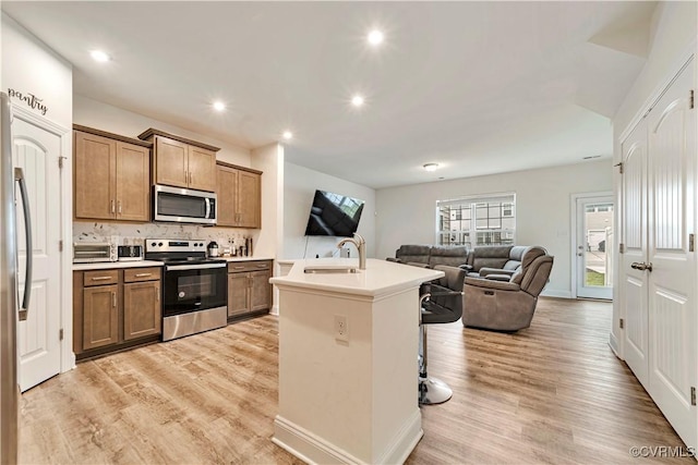6177 Bowline Ln, Richmond, VA 23234 - kitchen featuring appliances with stainless steel finishes, open floor plan, tasteful backsplash, light wood-style flooring, and recessed lighting