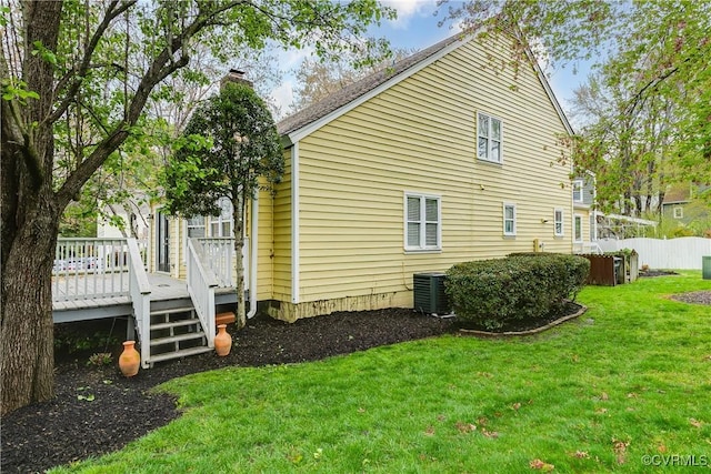 view of side of home with a wooden deck, central air condition unit, a lawn, fence, and a chimney