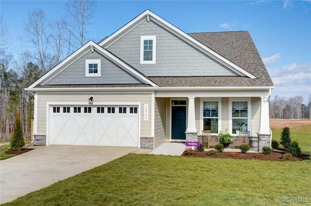 craftsman-style house featuring covered porch, stone siding, a front yard, roof with shingles, and driveway