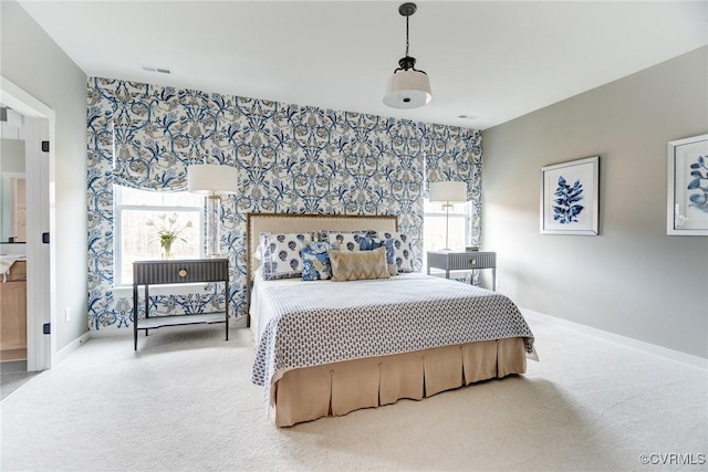 carpeted bedroom with baseboards, visible vents, wallpapered walls, and an accent wall