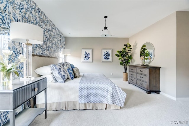 carpeted bedroom featuring wallpapered walls, baseboards, and an accent wall
