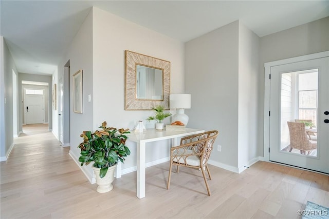 hall featuring baseboards and light wood-style flooring