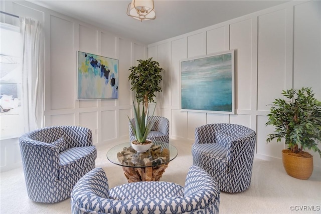 living area featuring carpet floors and a decorative wall