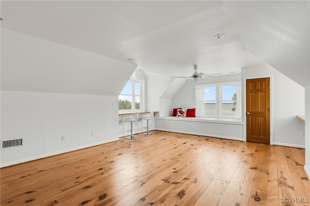 additional living space featuring visible vents, baseboards, light wood finished floors, and vaulted ceiling