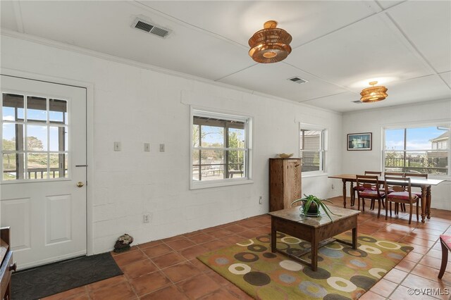 tiled living area featuring ornamental molding and visible vents