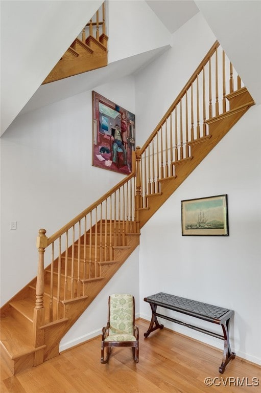 staircase featuring wood finished floors and baseboards