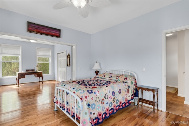 bedroom featuring wood finished floors, baseboards, and a ceiling fan