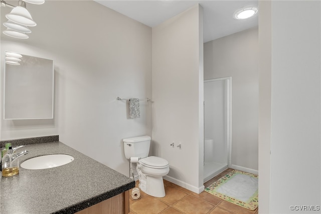 full bathroom with toilet, tile patterned floors, a stall shower, vanity, and baseboards