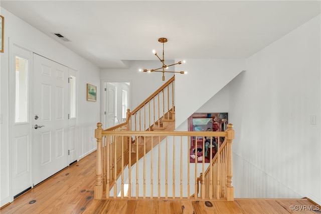 foyer featuring visible vents, a notable chandelier, and wood finished floors