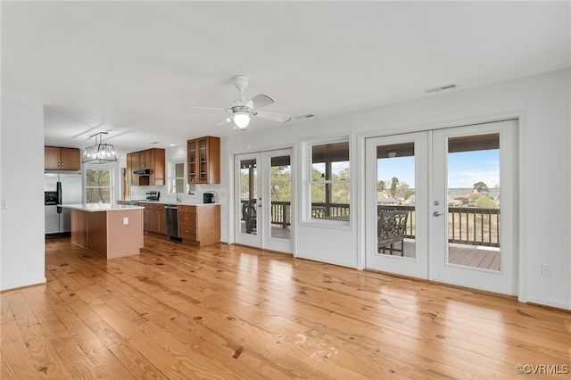 kitchen with visible vents, appliances with stainless steel finishes, light countertops, french doors, and brown cabinets