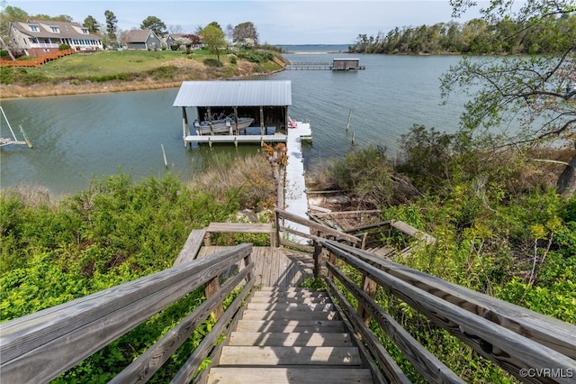 dock area with boat lift and a water view