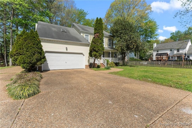 view of front of property featuring a front yard, driveway, fence, and an attached garage