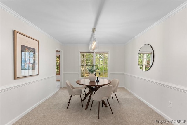 carpeted dining room with a healthy amount of sunlight, baseboards, and ornamental molding
