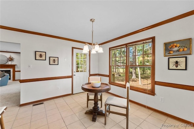 dining room with a healthy amount of sunlight, a notable chandelier, ornamental molding, and visible vents