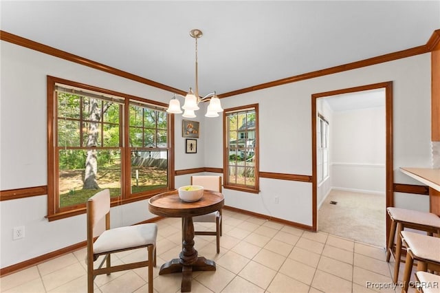 dining space with a chandelier, baseboards, ornamental molding, and a healthy amount of sunlight