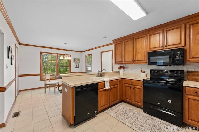 kitchen featuring a sink, light countertops, a peninsula, brown cabinetry, and black appliances