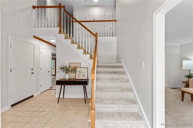 entrance foyer with baseboards, crown molding, and stairs