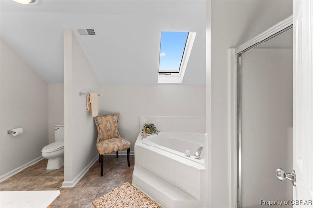 bathroom with a stall shower, vaulted ceiling with skylight, toilet, visible vents, and a garden tub