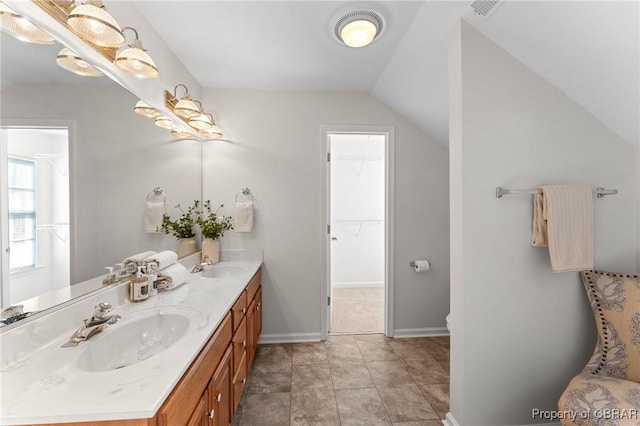 bathroom featuring a sink, visible vents, double vanity, and vaulted ceiling