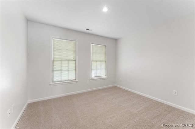 carpeted empty room with recessed lighting, visible vents, and baseboards