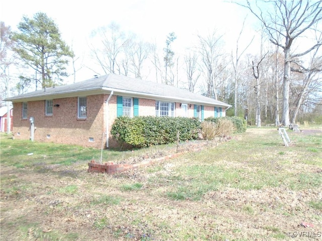 view of property exterior featuring brick siding, a lawn, and crawl space