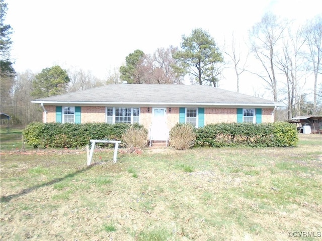 ranch-style house featuring brick siding and a front lawn