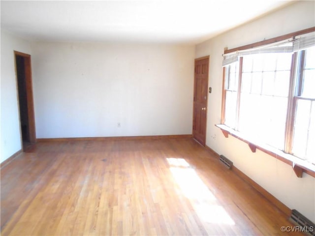 unfurnished room featuring visible vents, baseboards, and light wood-style floors